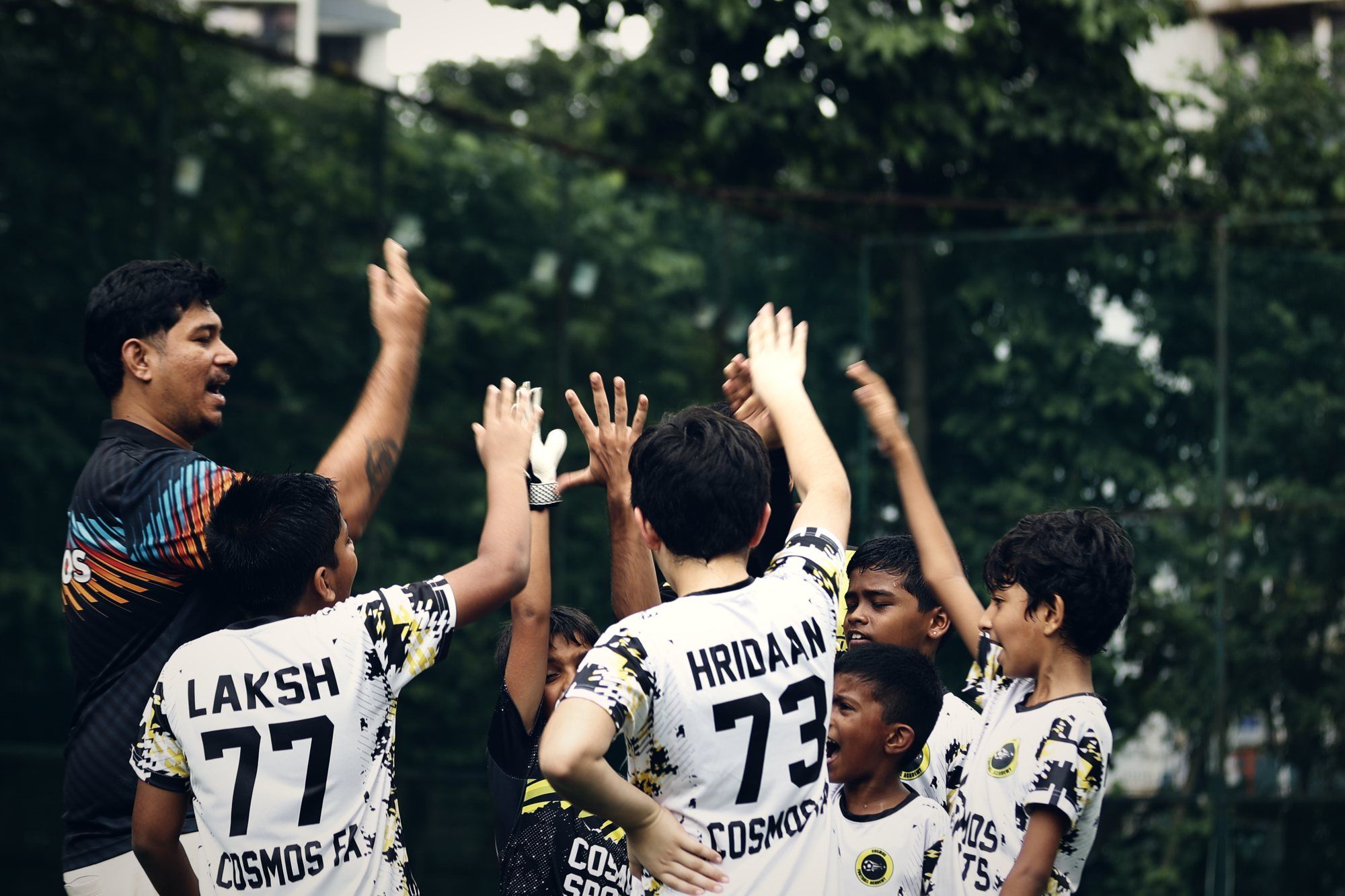 A Cosmos coach high-fiving young players