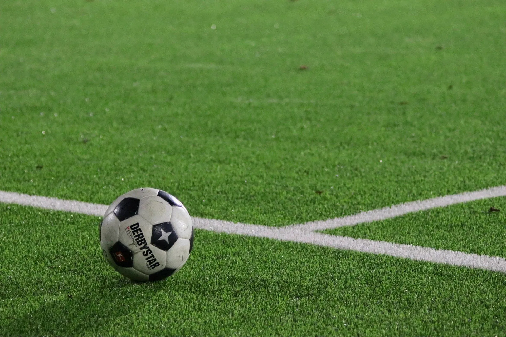 A football resting on a pitch line