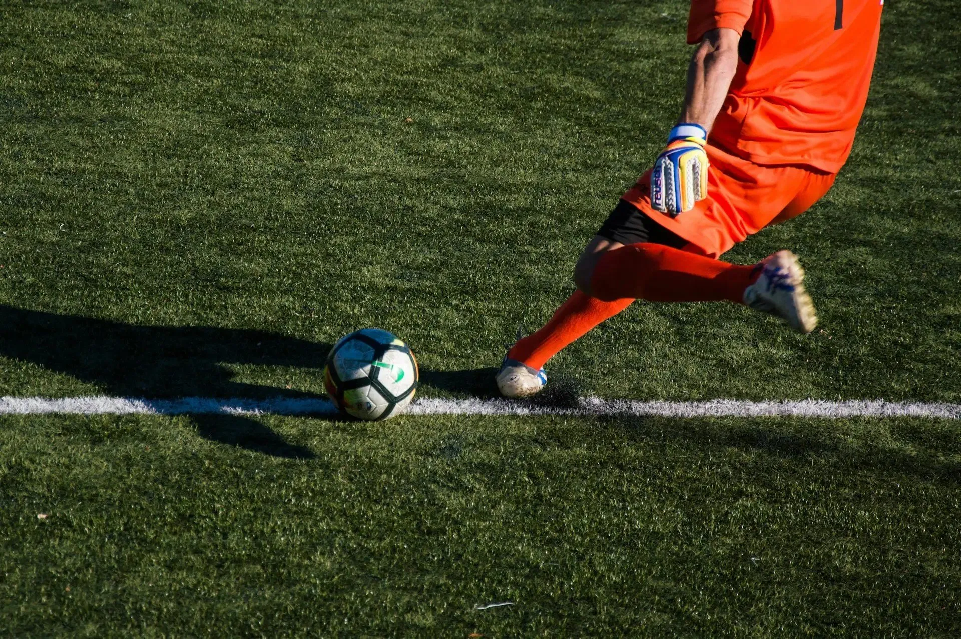 A goalkeeper striking the ball on the touchline