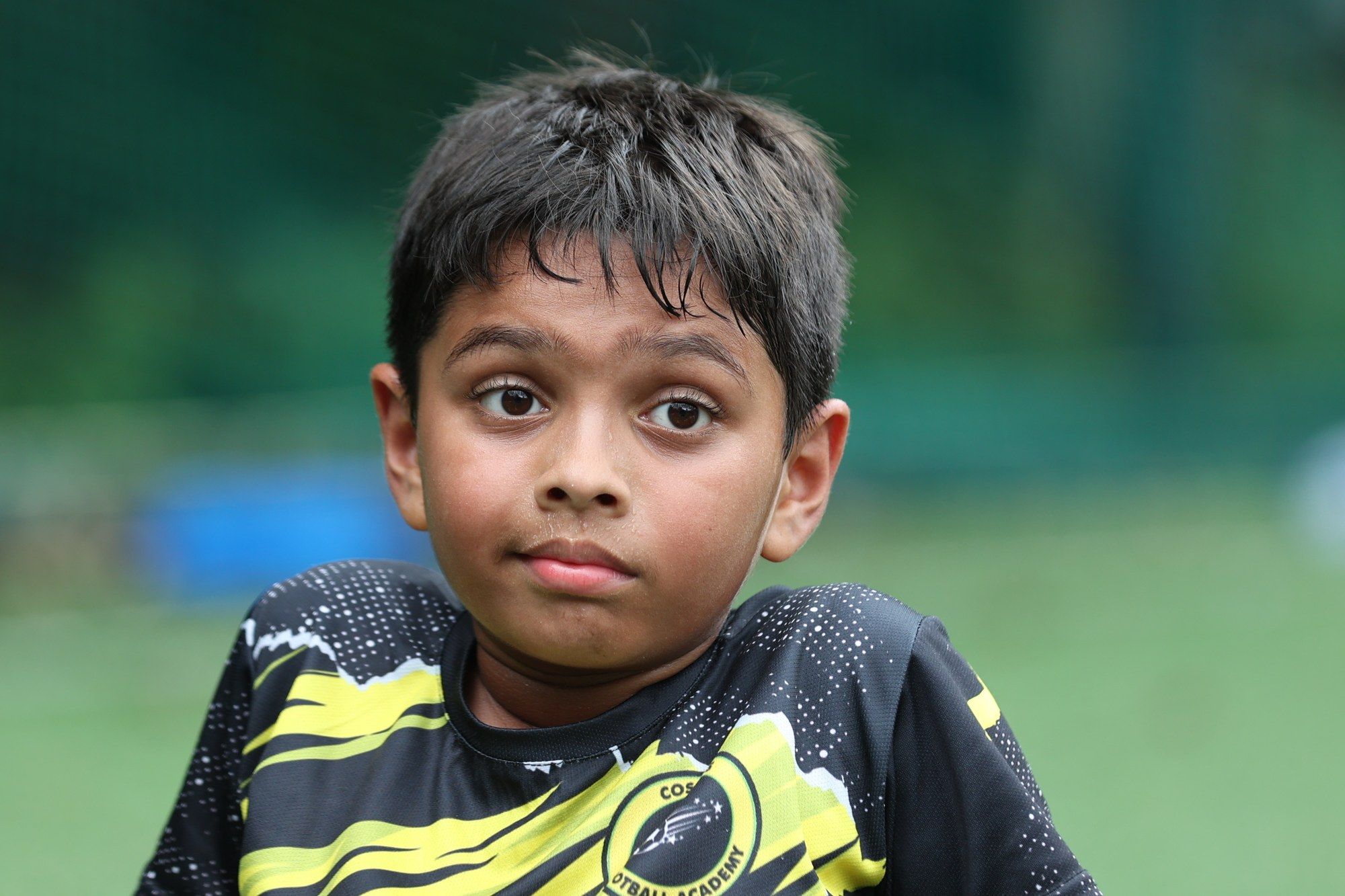 A young player in the yellow and black kit, wide-eyed