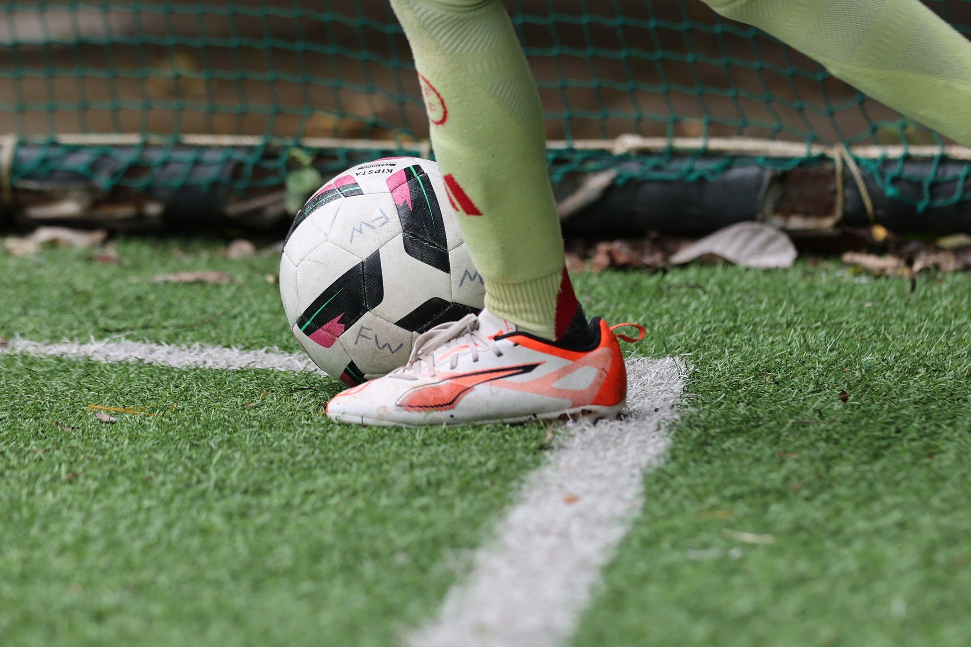 Close-up of a boot next to the ball on the line