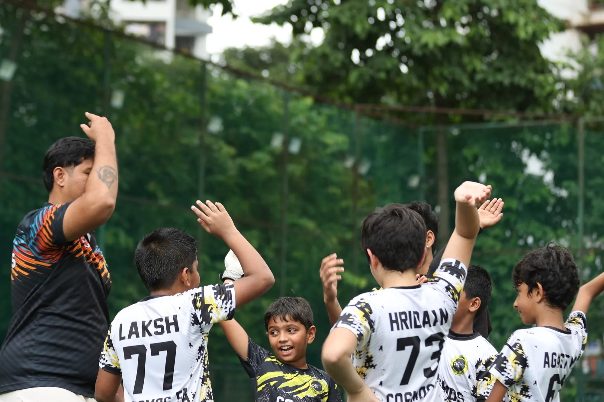Players celebrating a goal with their coach
