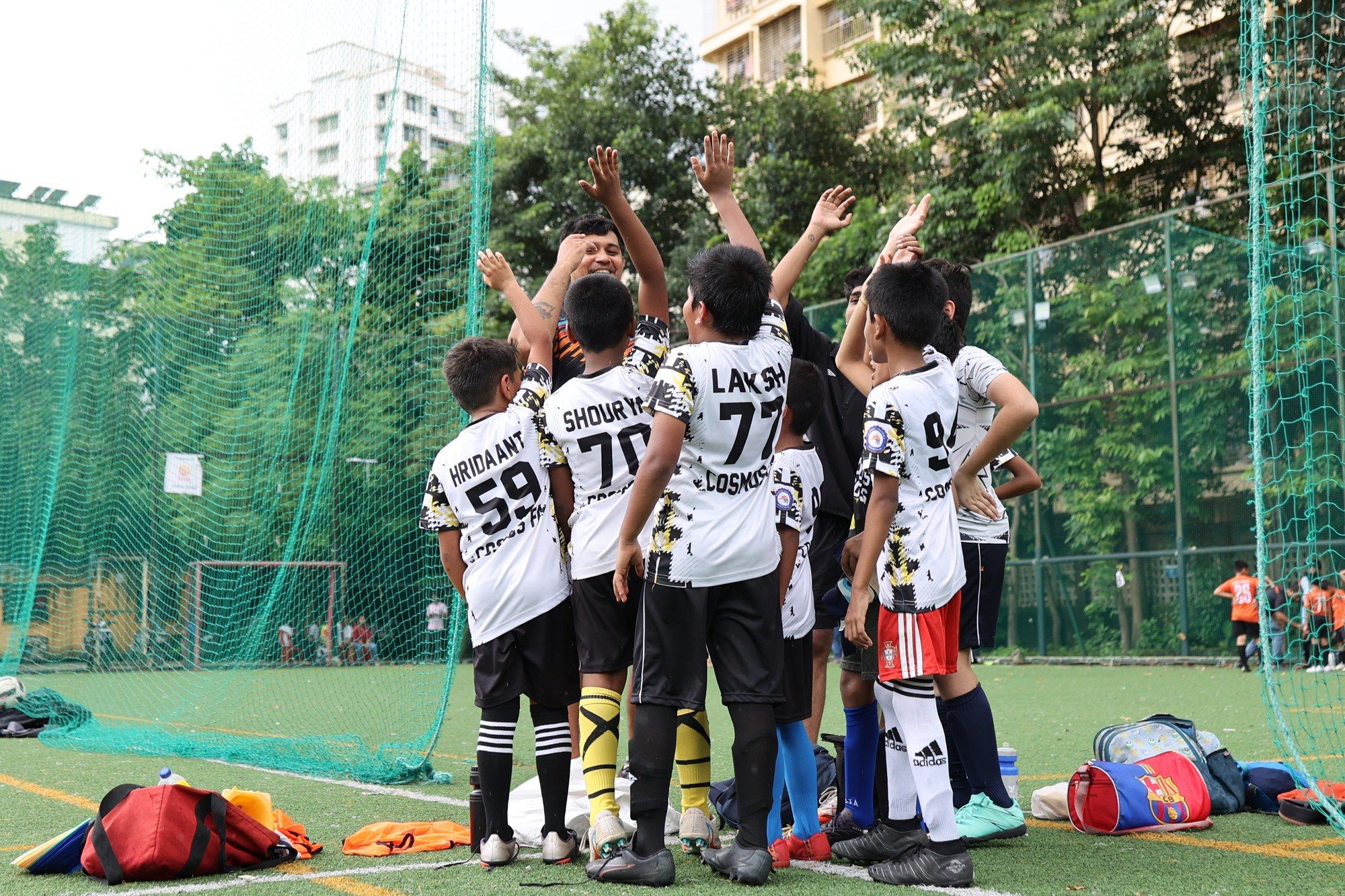 The squad in a huddle, arms raised
