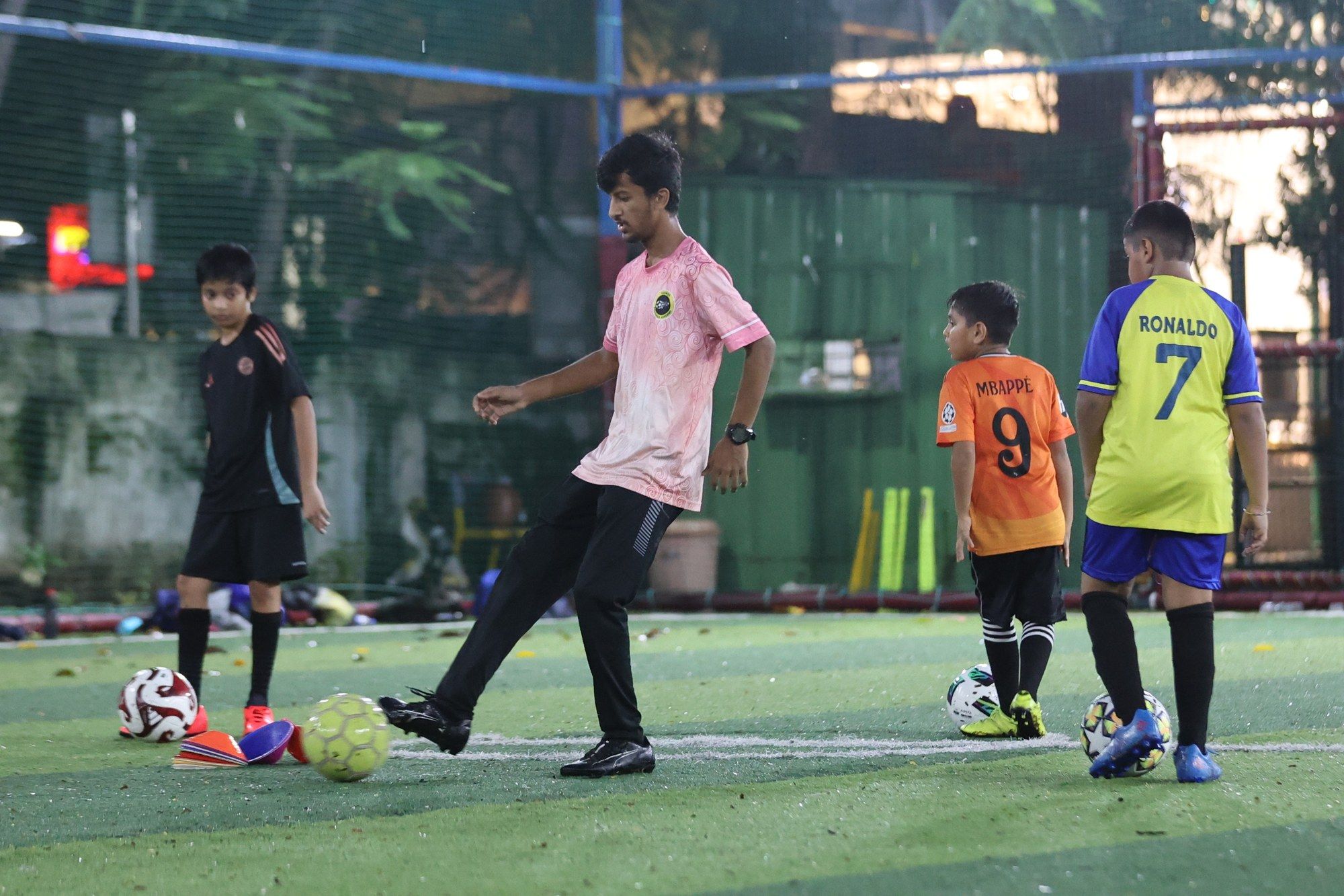 A coach and players during an evening training drill