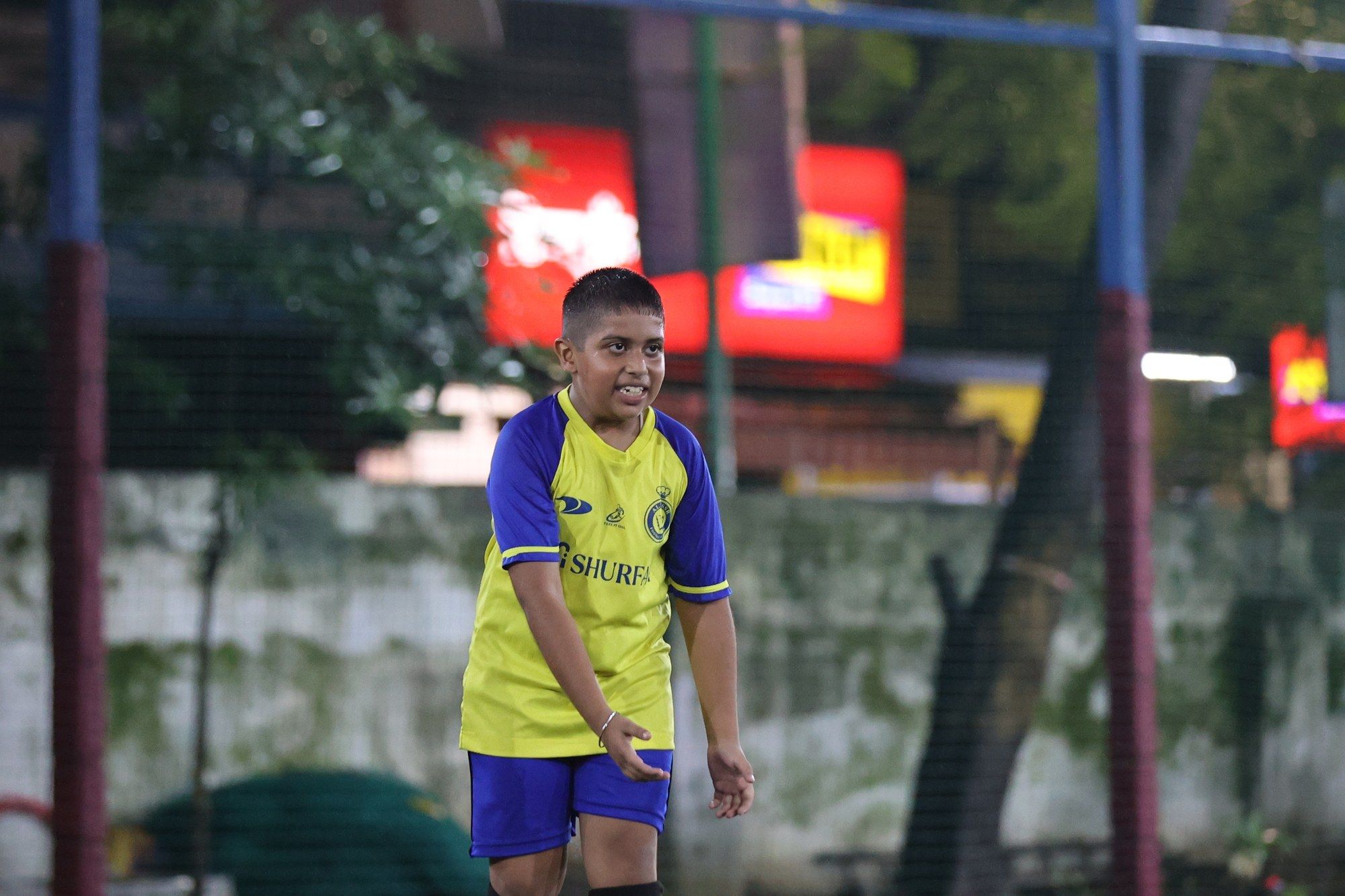 A player in a yellow shirt smiling at training