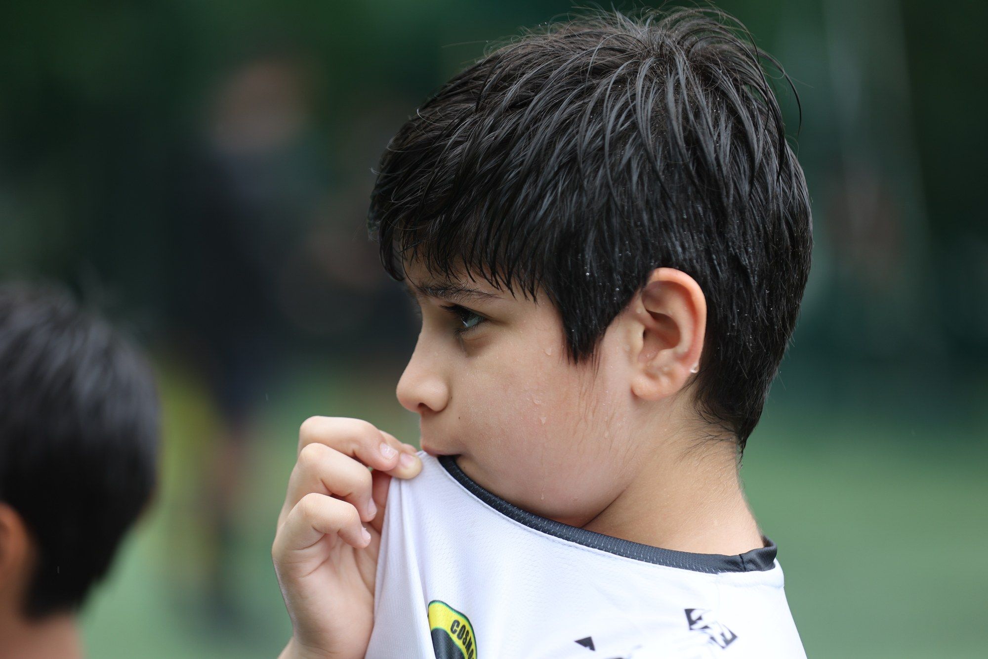 A young player tugging at his shirt collar