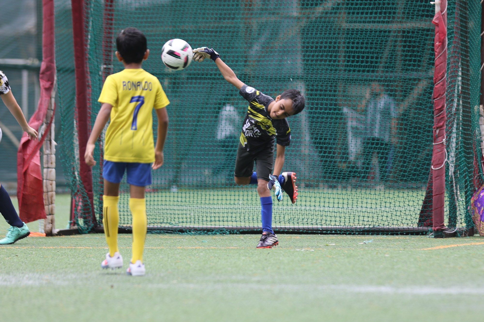 A goalkeeper diving to punch the ball