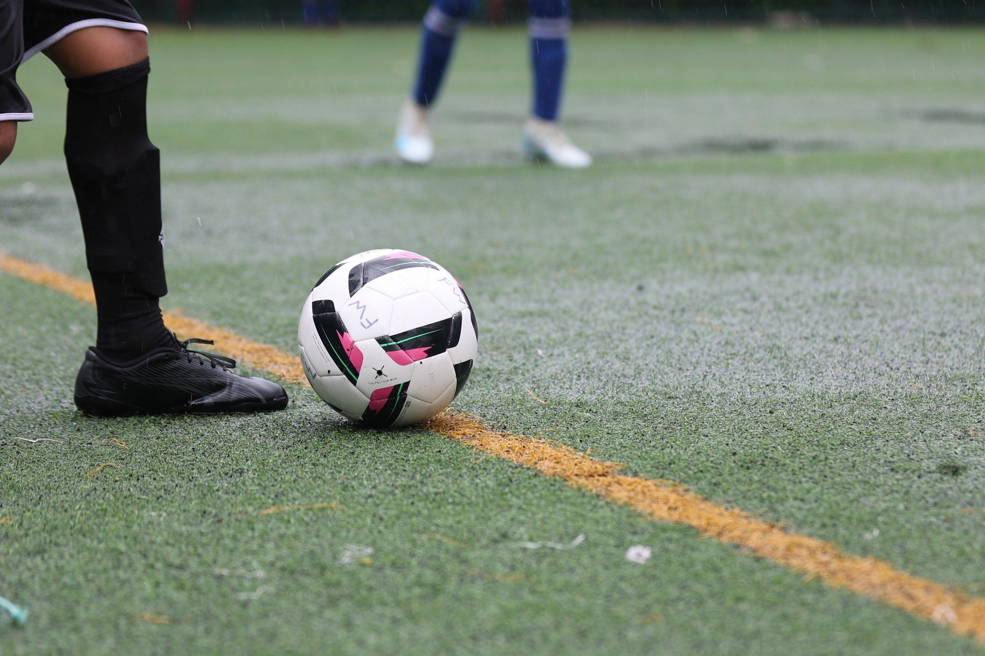 A boot and the ball on the turf