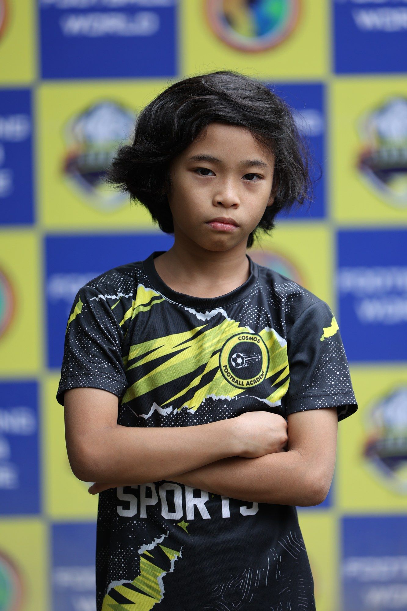A Cosmos player with arms crossed in front of the sponsor board
