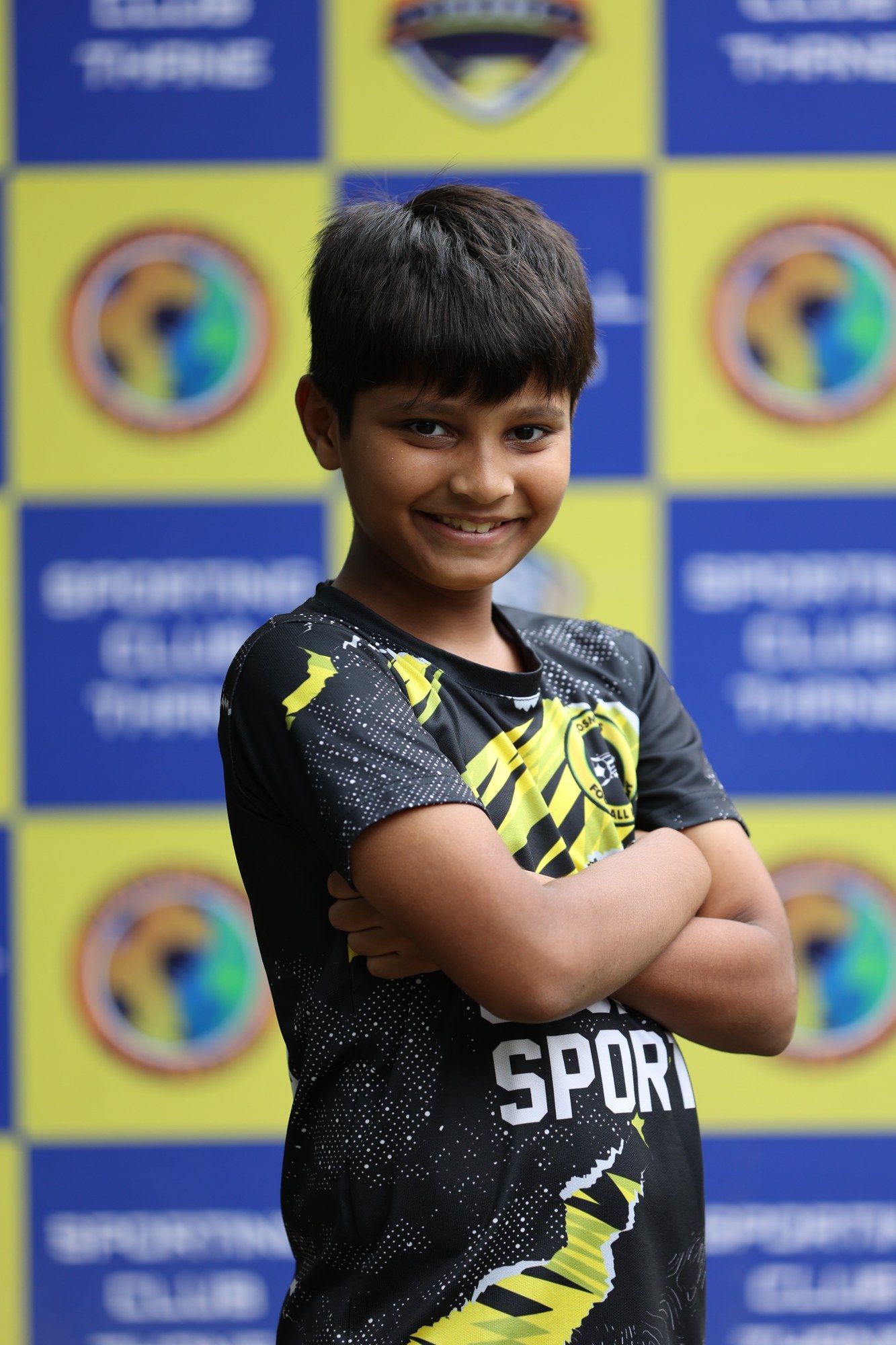 A grinning Cosmos player, arms crossed, on picture day