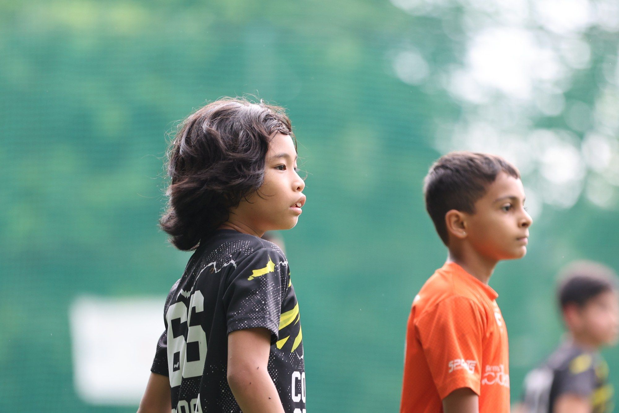 A player with long hair watching the game
